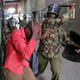 Policemen beat a protester inside a building during clashes in Nairobi.